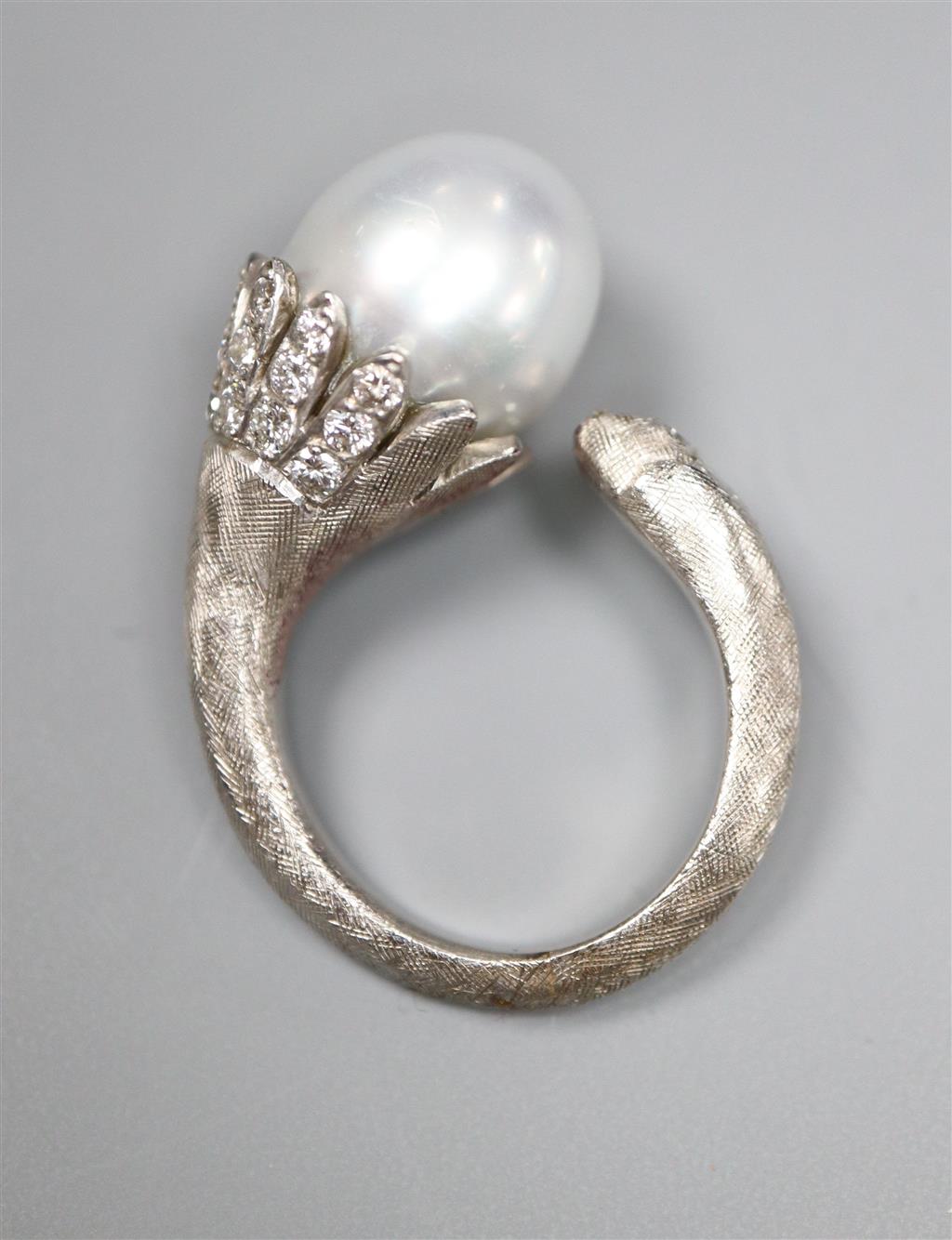 A modern textured white metal (possibly platinum), cultured pearl and diamond set openwork dress ring,